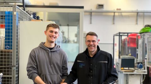 Zwei Männer halten einen Pedelec-Motor und zwei 3D-gedruckte Zahnräder in der Hand