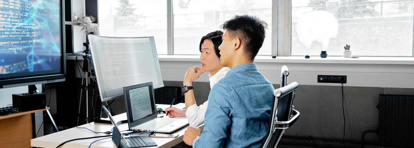 Zwei Männer sitzen vor einem PC