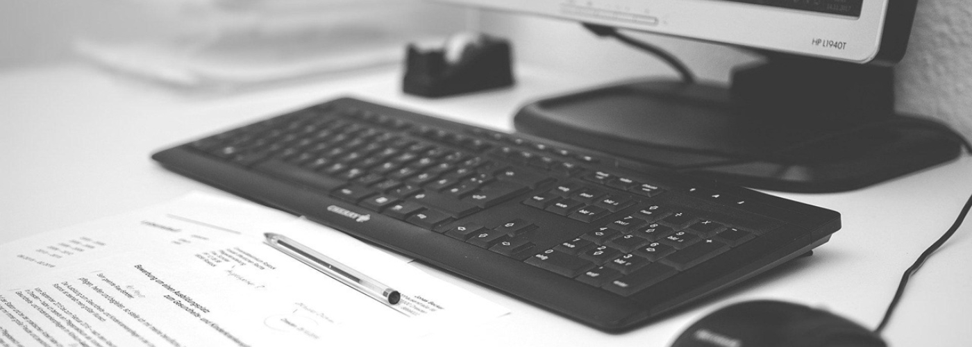 Ein Monitor, eine Tastatur und eine Maus auf einem weißen Tisch