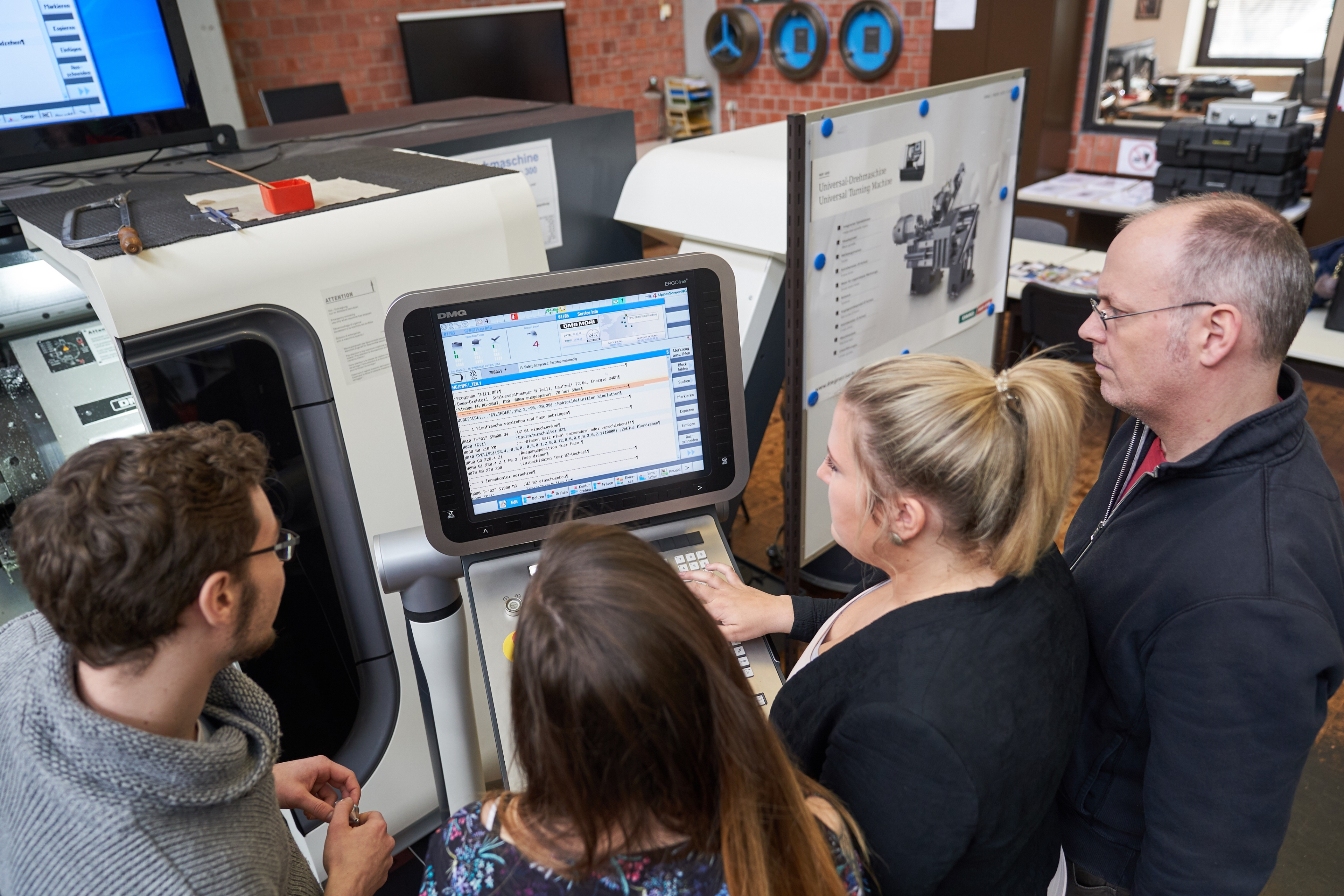 Mehrere Personen stehen vor einem Bildschirm