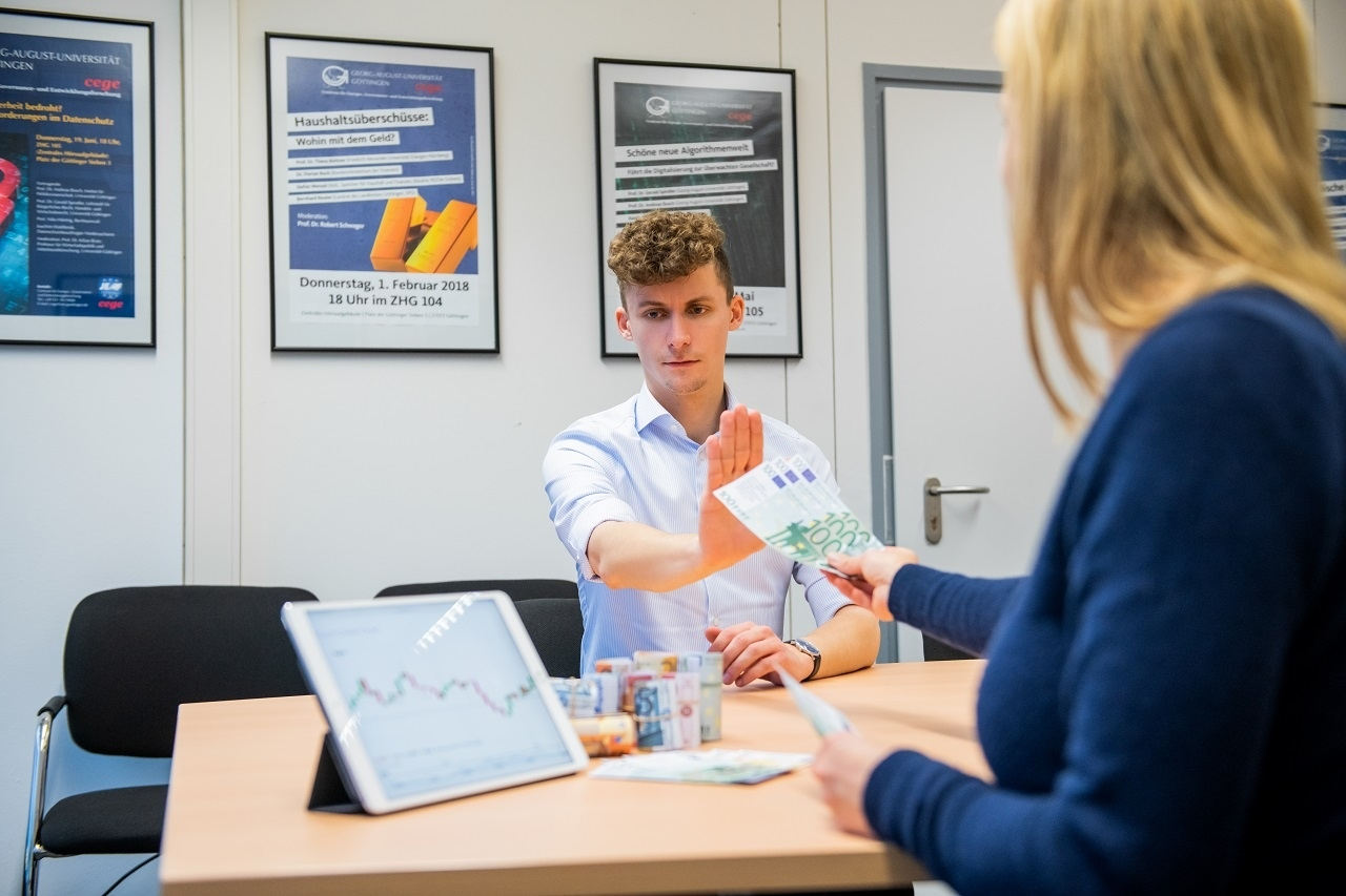 Person an einem Tisch lehnt Geld ab