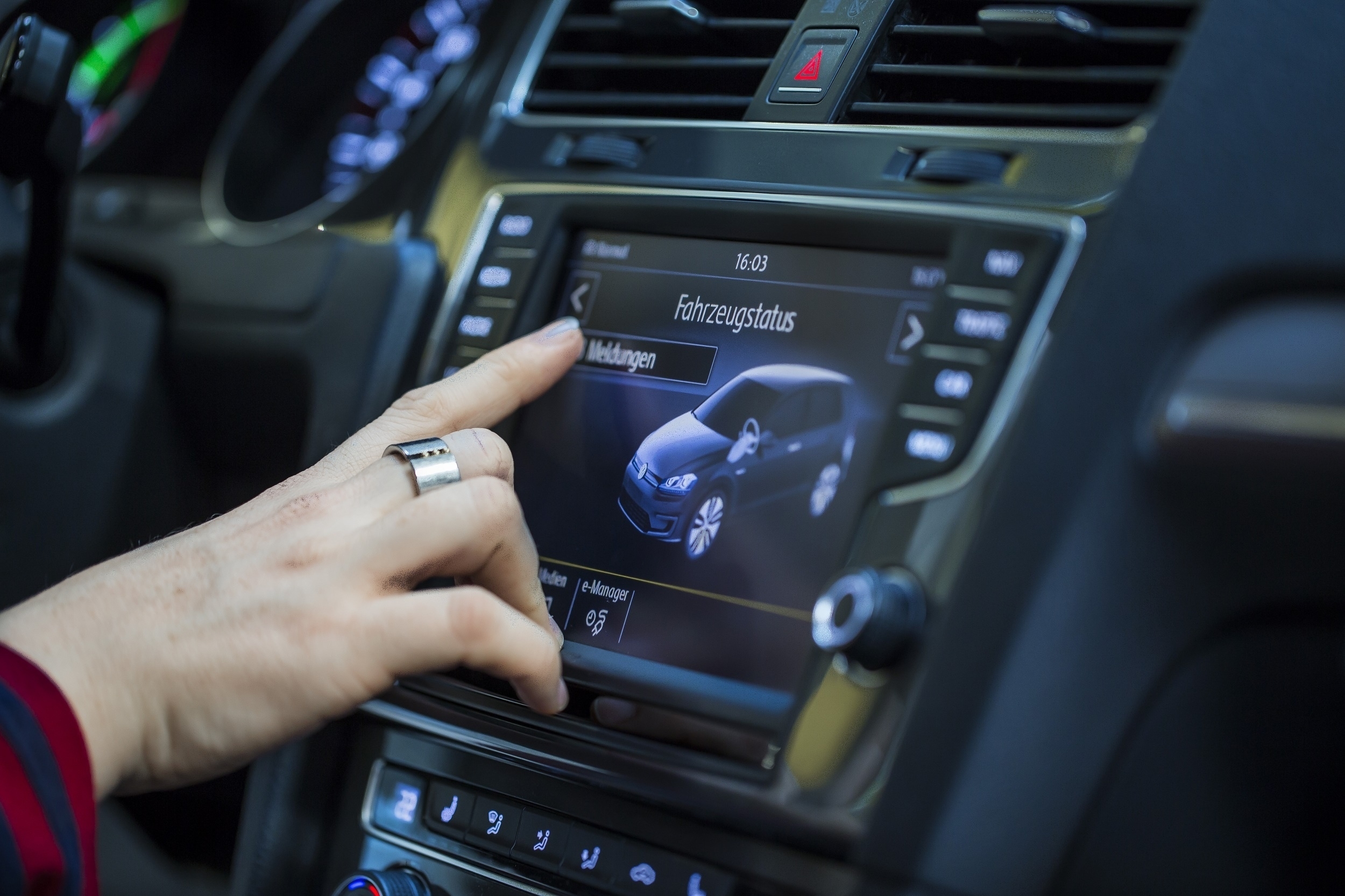 Person betätigt Bildschirm in einem Fahrzeug