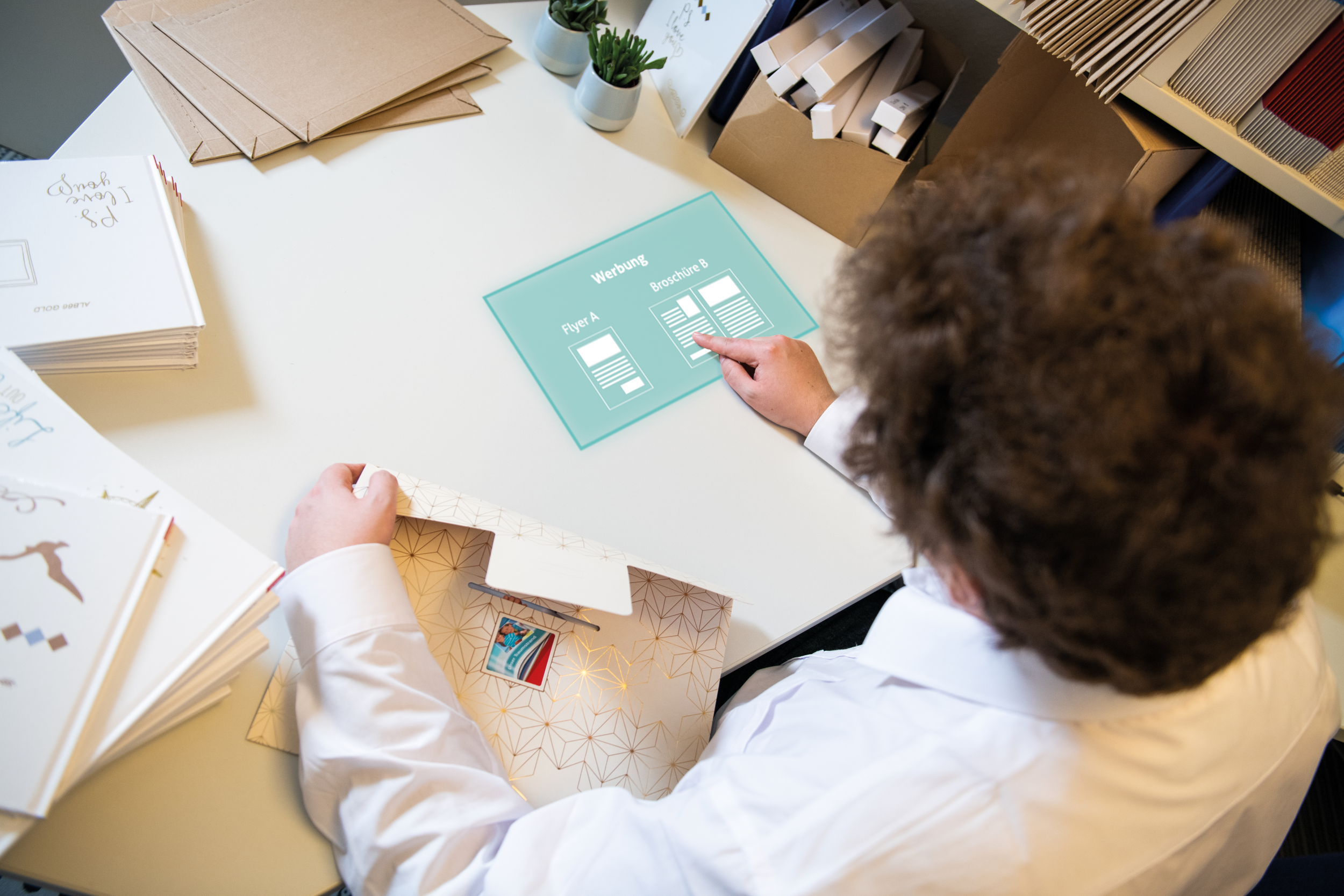 Person sitzt an Tisch mit Unterlagen