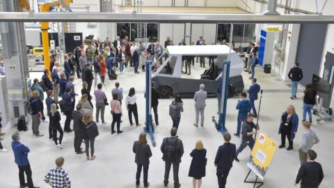 Eine Menschengruppe steht vor dem Prototypen eines Autos.