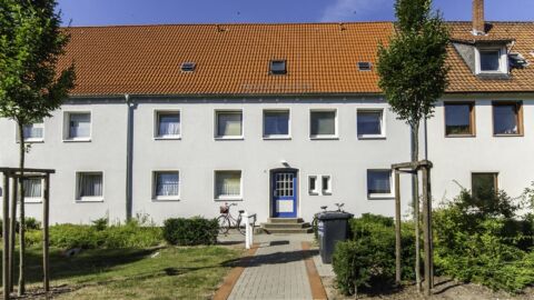 Weißes Reihenhaus mit Orangem Dach