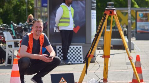 Mann mit Warnweste mit Werkzeugen zur Verkehrsmessung
