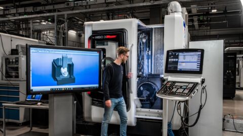 Mann steht vor Maschine