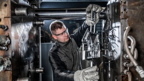 Mann arbeitet in Maschineninnenraum