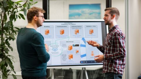 Zwei Personen stehen vor einem Bildschirm