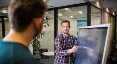 Mann zeigt Inhalte auf einem Bildschirm