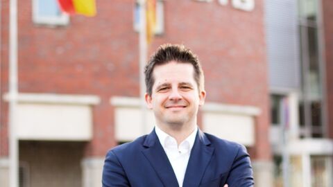 Prof. Dr. Sebastian Lehnhoff steht mit verschränkten Armen lächelnd vor dem OFFIS Gebäude