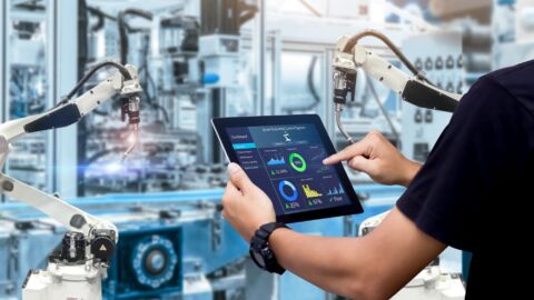 Person benutzt Tablet vor einer Maschine