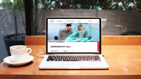 Laptop auf einem Tisch mit dem Jahresbericht 2021