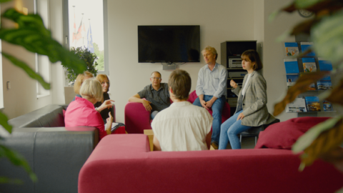 Personen verschiedenen Alters sitzen in einem Kreis und reden