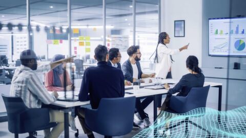 Menschen in einem hellen Konferenzraum diskutieren über eine Präsentation