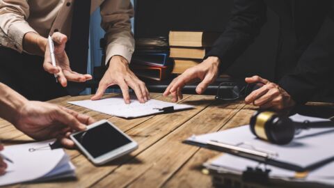 Mehrere Menschen arbeiten an einem Tisch zusammen