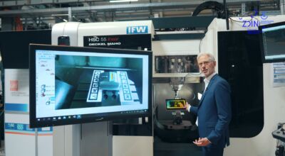 Ein Mann steht neben einem Monitor an einem Gerät