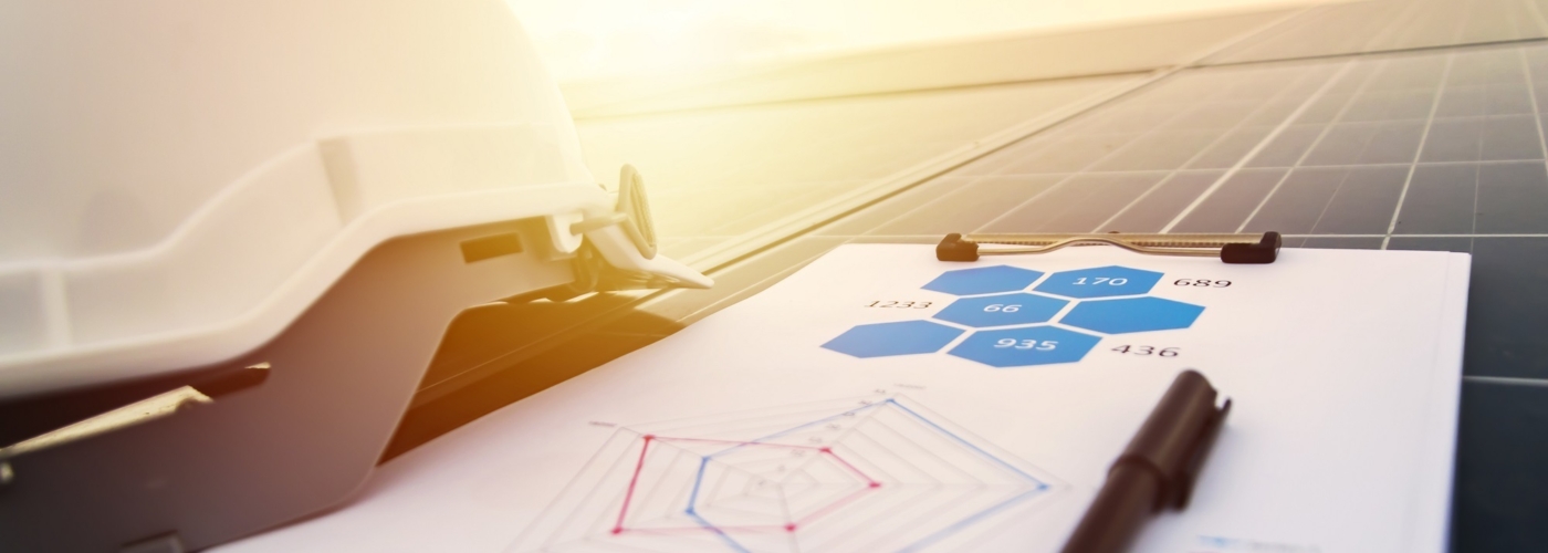 Helm und Arbeitsmappe liegen auf einem Solarpanel
