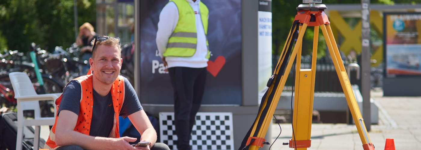 Mann mit Warnweste mit Werkzeugen zur Verkehrsmessung