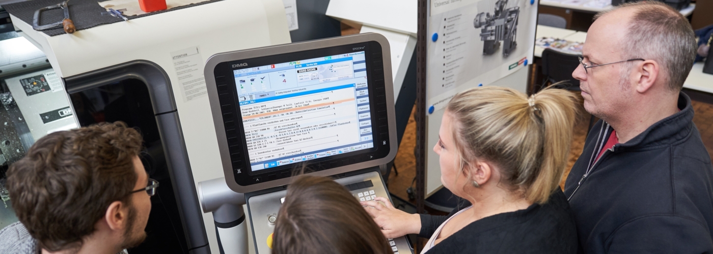 Mehrere Personen stehen vor einem Bildschirm