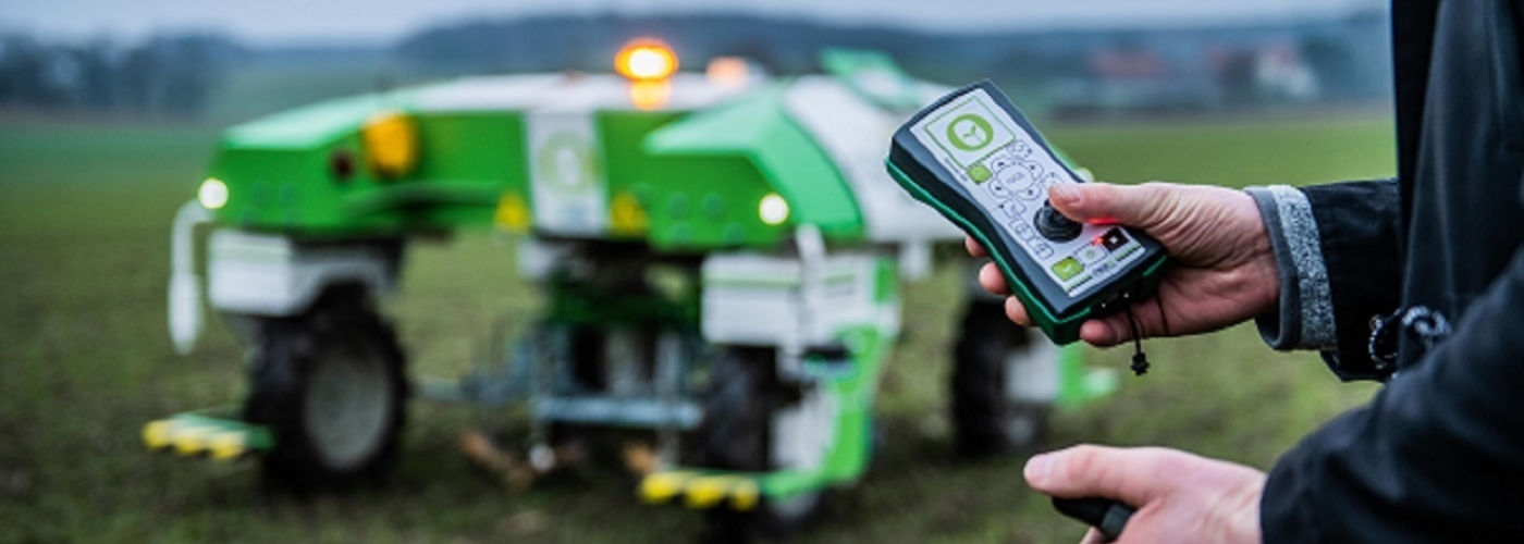 Landwirtschaftliche Maschine fährt über Feld und wird extern gesteuert