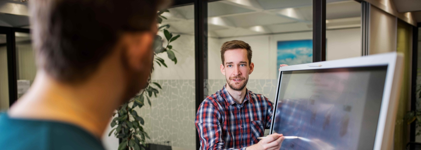 Mann zeigt Inhalte auf einem Bildschirm