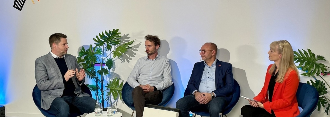 Vier Personen sitzen nebeneinander in einer Diskussionsrunde