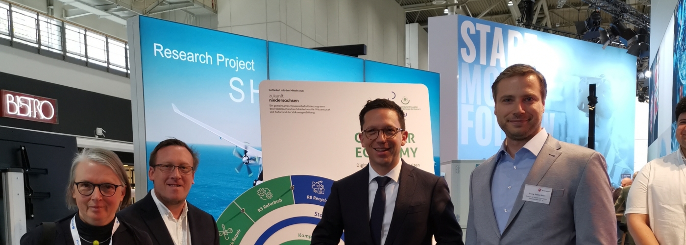 Vier Menschen an einem Messestand