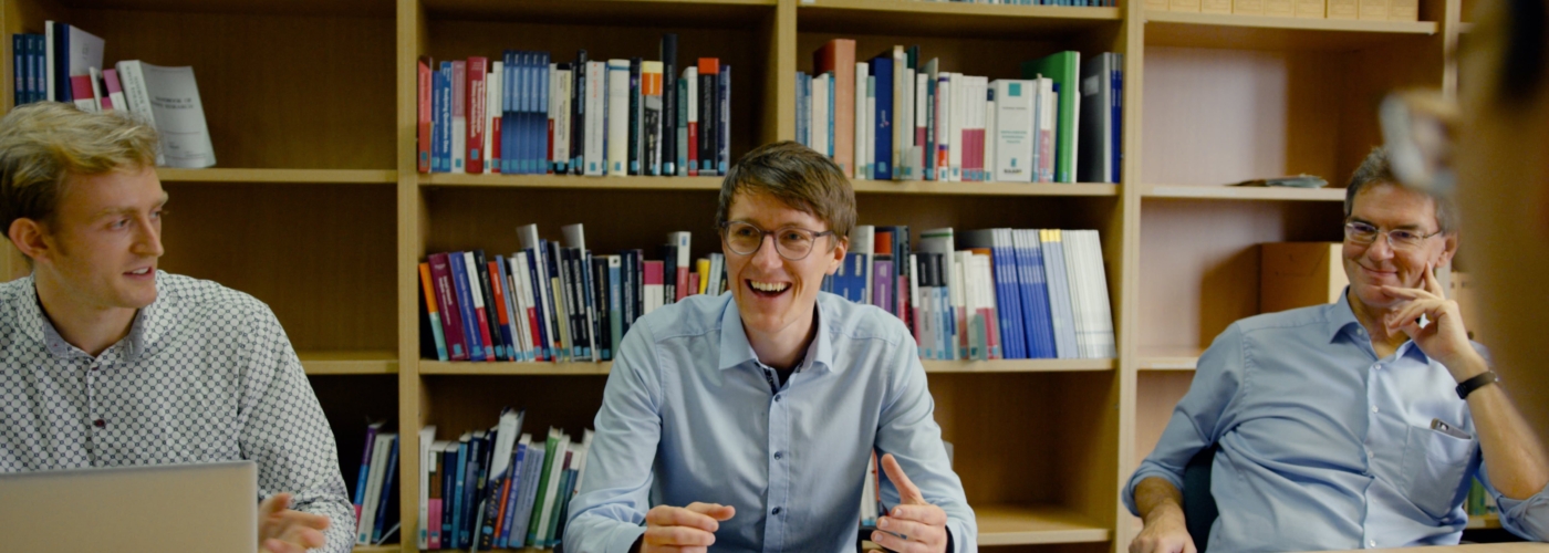 Männer sitzen an Tisch und lachen