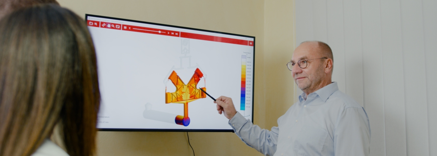 Mann erklärt etwas auf einem Bildschirm