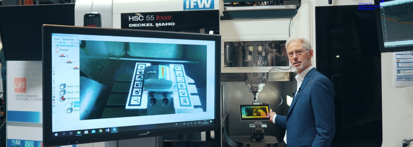 Ein Mann steht neben einem Monitor an einem Gerät