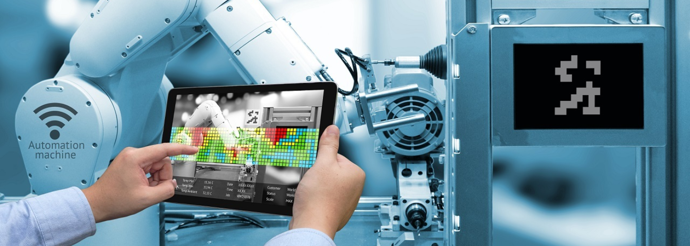 Person steht mit Tablet in der Hand vor einer Maschine