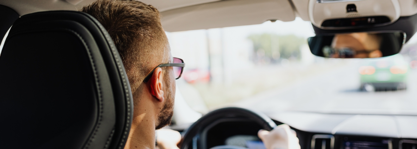 Person sitzt im Auto hinter dem Steuer