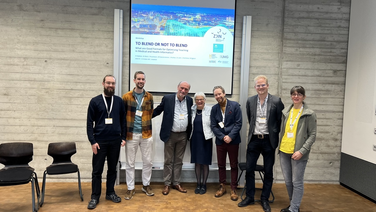 Gruppenbild von sieben Forschenden vor einer Wand